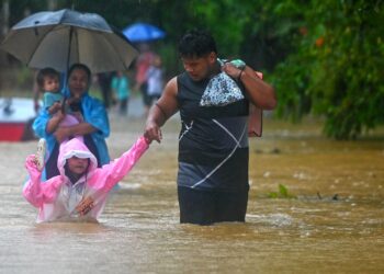 Penduduk Kampung Belimbing, Jongok Batu, Dungun meredah banjir untuk ke tempat lebih selamat semalam.