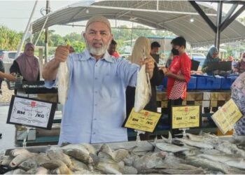 SYED Abu Hussin Hafiz Syed Abdul Fasal menunjukkan ikan yang dijual di di Pasar DSH, Puchong.