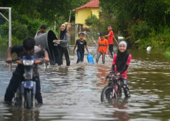 SEKUMPULAN kanak-kanak bermain banjir di Kampung Paya, Balai Besar, Dungun, hari ini. - UTUSAN/PUQTRA HAIRRY ROSLI