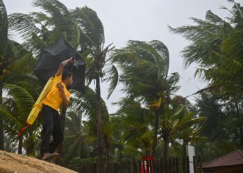 ANGGOTA Angkatan Pertahanan Awam Malaysia (APM) meninjau keadaan angin kencang dan laut bergelora di Pantai Pulau Kekabu, Marang.- UTUSAN/PUQTRA HARRY ROSLI