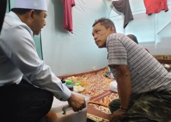 MOHD. Nassuruddin Daud (kiri) bertanya khabar keadaan penduduk yang terjejas dengan banjir di PPS Sekolag Kebangsaan (SK) Sri Kiambang, Pasir Mas, Kelantan hari ini-UTUSAN/ROHANA ISMAIL.