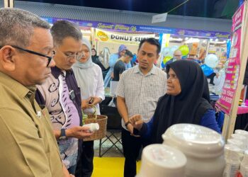 MOHAMAD Abdul Hamid (dua,kiri) dan Rashidi Zinol (kiri) meninjau reruai Pavilion Penangpreneur di tapak Pesta Pulau Pinang, George Town, Pulau Pinang, baru-baru ini. - Pix: SITI NUR MAS ERAH AMRAN