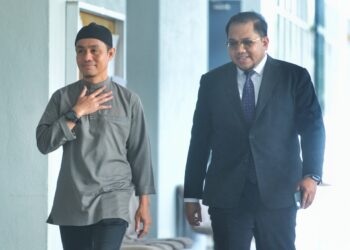 PU Azman (kiri) tiba di pekarangan Mahkamah Sesyen Seremban hari ini diiringan seorang peguamnya bagi perbicaraan kes amang seksual yang melibatkan dirinya.-UTUSAN/MOHD. SHAHJEHAN MAAMIN.