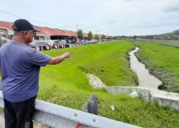 MD. JOHARI Dol menunjukkan aliran parit di Jalan Balau, Taman Desaru Utama di sini yang perlu diselenggara agar tidak berlaku limpahan air ke rumah penduduk. - UTUSAN/MASTURAH SURADI