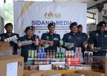 ABDUL Ghafar Mohamad (tengah) menunjukkan rokok dan arak seludup yang dirampas dalam tiga serbuan berasingan di Perak dan Johor, minggu lalu. - UTUSAN