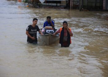 TIGA lelaki menggunakan perahu untuk mengangkat barang-barang keperluan setelah kawasan mereka dinaiki air di Rantau Panjang.-UTUSAN/KAMARUL BISMI KAMARUZAMAN