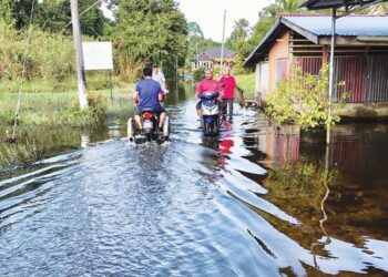 PENDUDUK terpaksa meredah air bertakung sejak sebulan lalu di Kampung Bunut Sarang Burung, Tumpat, Kelantan. - UTUSAN/ ROSLIZA MOHAMED