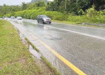 PENGGUNA laluan Jalan Gua Musang-Kuala Krai di Gua Musang, Kelantan terdedah kepada risiko kemalangan apabila keadaan permukaan jalan raya rosak dan berlubang.-UTUSAN/ AIMUNI TUAN LAH.