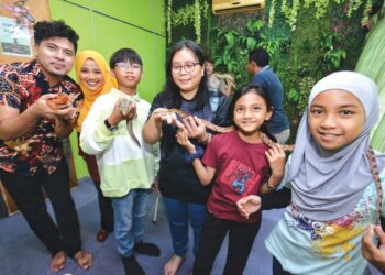 MOHD. Badrul Azhar Zulkapli (kiri) bersama para pelajar di Pusat Tuisyen Impian Bonda ketika menganjurkan program 'mini zoo' di pusat tuisyen itu di Taman Seri Telawi, Panchor, Seremban, Negeri Sembilan, semalam. - UTUSAN/MOHD. SHAHJEHAN MAAMIN