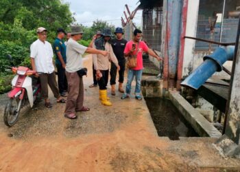 PENDUDUK menunjukkan pam air yang tidak berfungsi yang menjadi punca banjir kilat di sekitar Teluk Terimam di Bagan Datuk. - UTUSAN/AIN SAFRE BIDIN