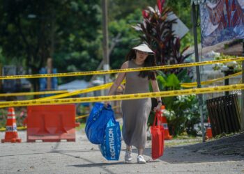 Seorang wanita mengambil barang penting selepas kejadian tanah runtuh di Taman Wawasan Puchong di sini, hari ini.