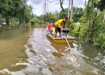 PENDUDUK terpaksa menggunakan bot enjin galah untuk urusan keluar masuk selepas kawasan rumah mereka ditenggelami banjir di Kampung Serongga, Pasir Mas, Kelantan-UTUSAN/ROHANA ISMAIL