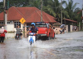 SEORANG penunggang motosikal meredah air banjir di Kampung Jejulok, Bachok, Kelantan-UTUSAN/KAMARUL BISMI KAMARUZAMAN