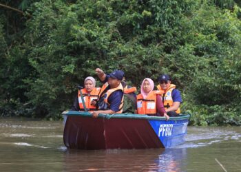ANGGOTA polis semasa melakukan rondaan menggunakan bot bagi memastikan tahap keselamatan rumah penduduk berada dalam keadaan baik di Kampung Serongga, Pasir Mas, Kelantan-UTUSAN/KAMARUL BISMI KARUZAMAN.
