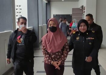 TERTUDUH (tengah) diiring oleh pegawai Kementerian Perdagangan Dalam Negeri dan Kos Sara Hidup (KPDN) semasa menghadiri prosiding di Mahkamah Sesyen Kota Bharu, Kelantan sebelum ini.-Gambar Fail