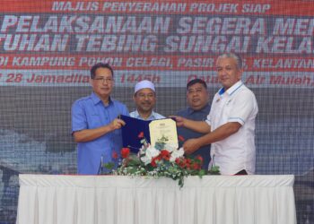 MOHD. Nassuruddin Daud (dua kiri) menyaksikan penyerahan dokumen Projek Pelaksanaan Segera Menangani Runtuhan Tebing Sungai Kelantan di Kampung Pohon Celagi,  Pasir Mas, Kelantan hari ini.-UTUSAN/KAMARUL BISMI KAMARUZAMAN