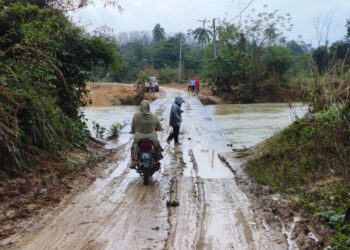 PENDUDUK kembali menggunakan Jambatan Pasir Jering, Kuala Krai yang sudah dibaiki selepas runtuh sebelum ini.-YATIMIN/ABDULLAH