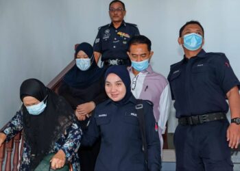 KESEMUA tertuduh diiring keluar anggota polis selepas didakwa di Mahkamah Sesyen, Ayer Keroh, Melaka atas pertuduhan menggunakan dokumen palsu bagi tujuan penukaran hak milik tanah. - UTUSAN/SYAFEEQ AHMAD