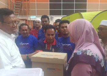 AHMAD Shabery Cheek (kiri) menyampaikan kit bantuan banjir kepada salah seorang mangsa banjir kilat di Felda Kerteh 4, Dungun, Terengganu. - UTUSAN/NIK NUR IZZATUL HAZWANI NIK ADNAN