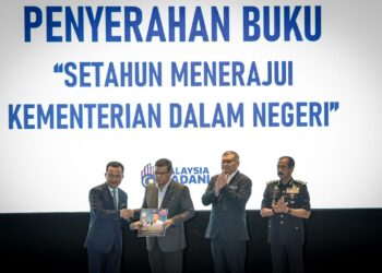 KETUA Setiausaha Kementerian Dalam Negeri, Datuk Ruji Ubi menyerahkan buku  ‘Setahun Menerajui Kementerian Dalam Negeri’ kepada Saifuddin Nasution Ismail semasa Sambutan Setahun MADANI di Putrajaya semalam. – UTUSAN/FAIZ ALIF ZUBIR