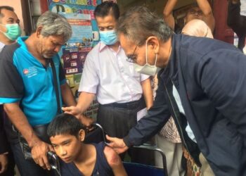 DR. DZULKEFLY Ahmad (kanan) melihat keadaan salah seorang mangsa banjir di pusat pemindahan sementara (PPS) Sekolah Kebangsaan (SK) Jeli, Kelantan. - UTUSAN/ROSMIZAN RESDI