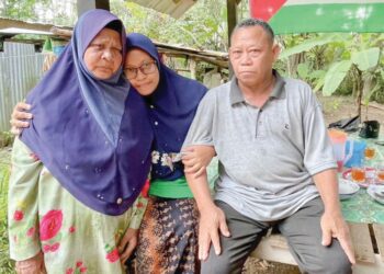 SITI Mariah Hamzah (tengah) memeluk Che Safuan Abd. Rahman dan Hamzah Said selepas mereka bertemu semula di Kampung Sireh, Kuala Nerang di Padang Terap, Kedah.