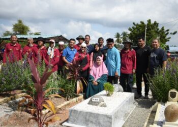 NORAIZAD Rosli (lima dari kiri), Che Ana Abdullah (depan) dan pelakon Harun Hashim selaku ikon Fitrah Enterprise (empat dari kanan) serta ahli keluarga mangsa dan sukarelawan Maqam al-Firdausi bergambar di pusara Shaharul Amir di Seri Manjung. - UTUSAN