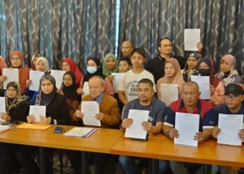 KAMARUDIN Ahmad (duduk, tengah) bersama sebahagian mangsa pencemaran Sungai Kim Kim di Bandar Seri Alam, Johor Bahru, hari ini.