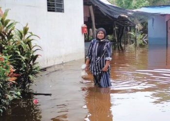 MEK Mani Kadir meredah banjir termenung di kawasan rumahnya di Kampung Permaisuri, Setiu, Terengganu. - UTUSAN/WAN ZURATIKAH IFFAH WAN ZULKIFLI