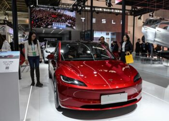 ORANG ramai mencuba kenderaan elektrik Tesla Model 3 di ruang pameran semasa Ekspo Rantaian Bekalan Antarabangsa China (CISCE) di Beijing pada 1 Disember 2023.-AFP