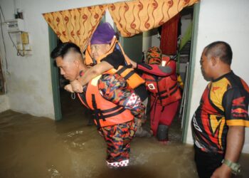 ANGGOTA bomba membawa seorang mangsa banjir, Sri Wahyuni Ahmad yang menghidap penyakit gout dan buah pinggang di SK Kampung Laut, Johor Bahru yang dilanda banjir.