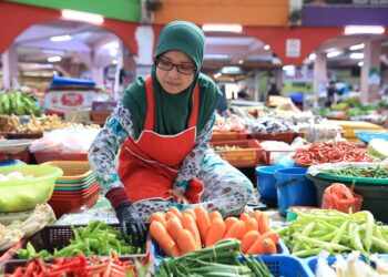 SEORANG peniaga menyusun sayur-sayuran yang dijualnya di Pasar Siti Khadijah, Kota Bharu, Kelantan-UTUSAN/KAMARUL BISMI KAMARUZAMAN.