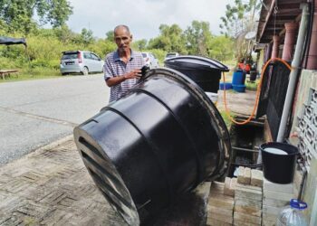 ABDUL Rahim Razak menunjukkan tangki air yang dibeli untuk menyimpan air setelah berlaku gangguan bekalan air di Perumahan Pengkalan Nyireh 2, Besut, Terengganu, semalam. - UTUSAN/WAN ZURATIKAH IFFAH WAN ZULKIFLI