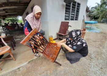 NURASHAH Jaffar (kanan) dan adiknya, Siti Rohani membersihkan perabot rumah di Kampung Kelantan, Kota Tinggi.