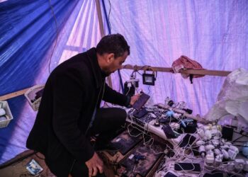 SEORANG lelaki Palestin menjana kuasa elektrik dengan panel solar untuk membantu penduduk mengecas telefon mereka di khemah sementara di Rafah.-AGENSI