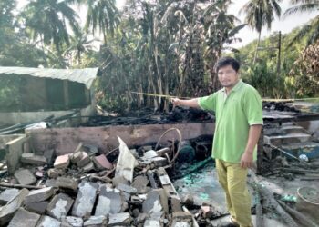 SUHAIMI Abu Bakar menunjukkan rumahnya yang terbakar di  Parit Haji Omar Laut, Api-Api, Pontian.