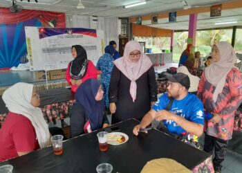 FAUZIAH (berdiri dua dari kanan) ketika melawat PPS Sekolah Kebangsaan Felda Air Tawar 1, Kota Tinggi yang menempatkan penduduk terjejas akibat banjir kilat yang berlaku.