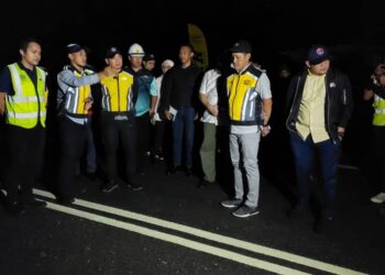 ONN HAFIZ GHAZI (tiga dari kiri) mendengar taklimat berkaitan pemasangan garisan bercahaya dalam gelap (glow in the dark) yang dipasang di Jalan Simpang Renggam - Renggam ketika melakukan lawatan kerja malam tadi.