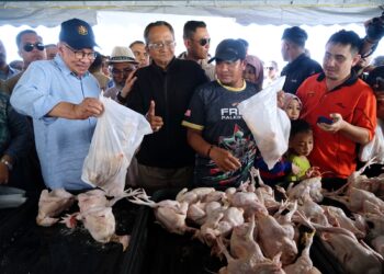 ANWAR Ibrahim (kiri) melawat gerai jualan pada Program Jualan Termurah Madani Barang Basah dan Kering di Padang Taman Klebang Restu, Ipoh semalam. - UTUSAN/ZULFACHRI ZULKIFLI