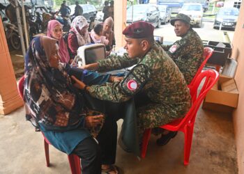 ANGGOTA Pasukan Forward Medical Team (FMT) daripada Angkatan Tentera Malaysia (ATM) melakukan pemeriksaan kesihatan mangsa banjir di PPS Kampung Shukor, Hulu Dungun, Dungun. - UTUSAN/PUQTRA HAIRRY ROSLI