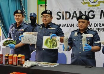 ISMAIL Hashim (kanan) menunjukkan gulungan ketum yang siap dibungkus dalam sidang akhbar di pejabat Kastam Padang Besar, Perlis hari ini.- UTUSAN/SYED AZLAN SAYID HIZAR