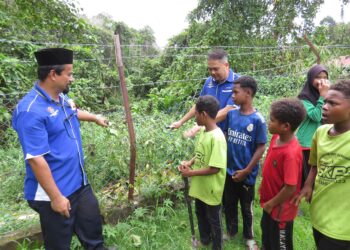 MAT Ail Ibrahim (kiri) bersama Tuan Almadi Tuan Kasim menunjukkan pagar sekolah yang dirosakkan di Sekolah Kebangsaan (SK) Pasir Linggi di Kampung Pasir Linggi, Pos Lebir, Gua Musang semalam.– UTUSAN/ AIMUNI TUAN LAH