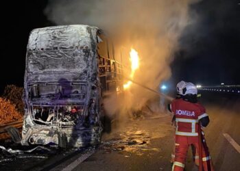 ANGGOTA bomba memadamkan kebakaran sebuah bas ekspres dua tingkat di Kilometer 375.4, Lebuh Raya Utara-Selatan arah utara Tanjung Malim hari ini. - UTUSAN/IHSAN JBPM