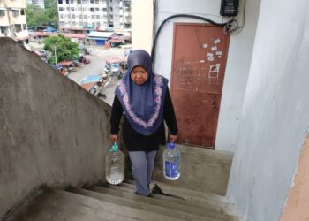 Faridah Hashim mengangkut air ke rumahnya di tingkat empat Flat Taman Sahabat, Teluk Kumbar, setiap kali berlaku gangguan bekalan air.