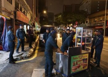 ANGGOTA Dewan Bandaraya Kuala Lumpur menyita gerai makanan yang dipercayai beroperasi tanpa lesen di Chow Kit, Kuala Lumpur. - FB DBKL