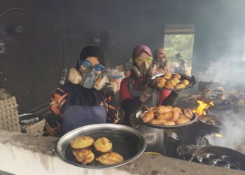 RAJA Nurul Wahida Raja Ramli (kiri) bersama dua lagi pekerja menggunakan gogel ketika proses membakar kuih-muih di gerai Kuih Asap Kelong di Manir, Kuala Terengganu. -  UTUSAN/KAMALIZA KAMARUDDIN