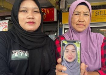 NORISHAM Samsusah (kiri) dan ibunya Noraini Salleh menunjukkan gambar Mira Sharmila yang hilang sejak 14 Disember lalu.