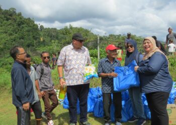 RUBIAH Wang (kanan) menyantuni masyarakat Orang Asli di Kampung Jader, Pos Simpor, Gua Musang, Kelantan hari ini.UTUSAN/AIMUNI TUAN LAH