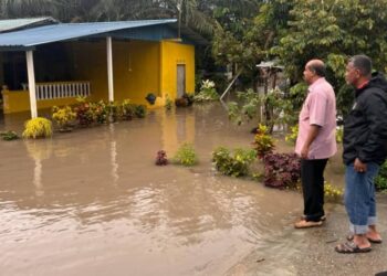 R. VIDYANANTHAN (kiri) meninjau keadaan banjir di Kampung Contoh, Kahang, Kluang.