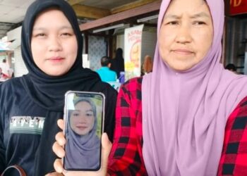 NORISHAM Samsusah (kiri) dan ibunya, Noraini Salleh menunjukkan gambar Bella yang masih belum ditemukan sejak dilaporkan hilang 14 Disember lalu.